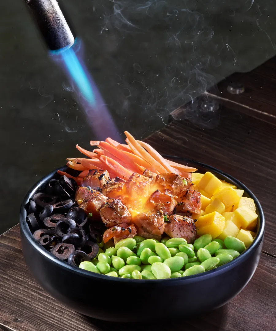 A blowtorch finishing a bowl of shoyu salmon